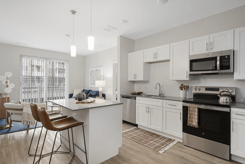 A modern kitchen with white cabinets and a large island.