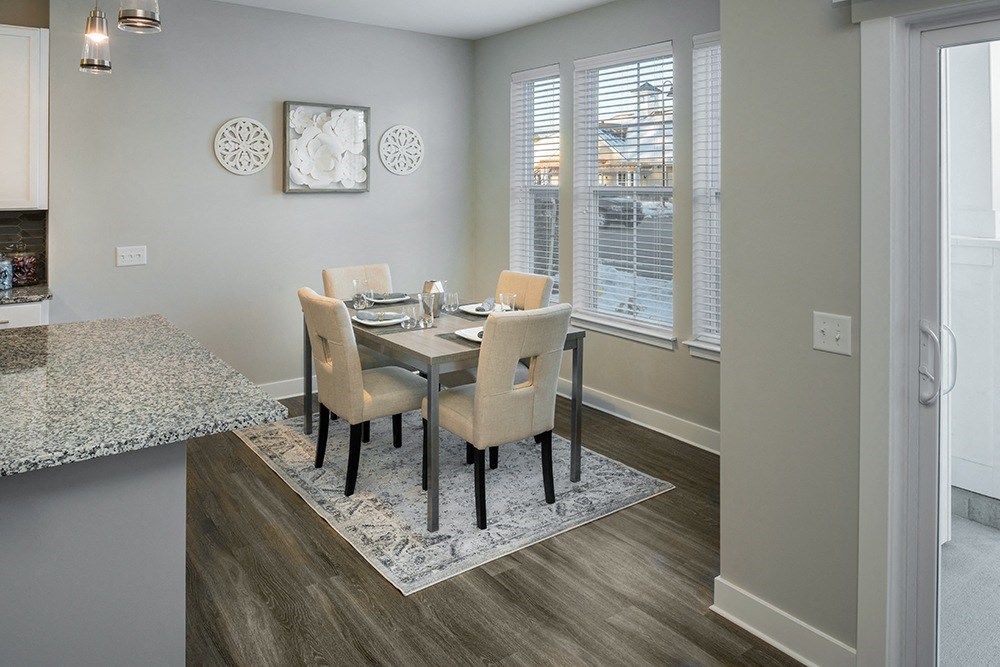 a dining room with a table and chairs and a window at The Beacon at Gateway Apartments, Scarborough, ME, 04074