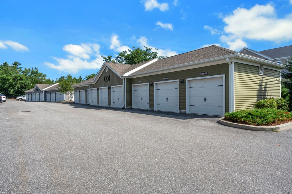 a row of garages with cars parked in front of them at The Beacon at Gateway Apartments, Scarborough, ME, 04074