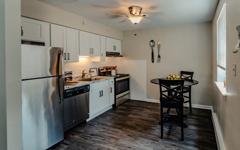 a kitchen with white cabinets and stainless steel appliances