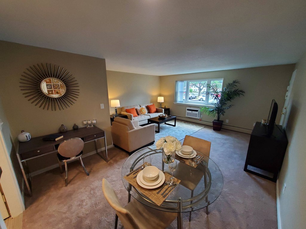 an open living room and dining room with a glass table at Greenfield Village Apartments, Rocky Hill, CT