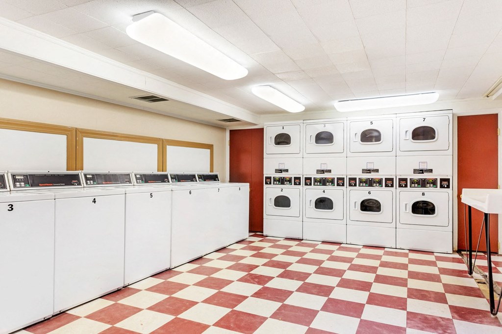 Laundry room with many washers and dryers and a checkered floor at Griswold Gardens in Glastonbury, CT, 06033