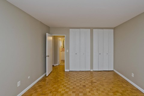 a living room with a wood floor and white closets on the wall