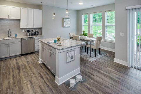 an open kitchen and dining room with a table and chairs an open kitchen and dining room with a table and chairs at The Residences at Crosstree, Freeport, ME, 04096