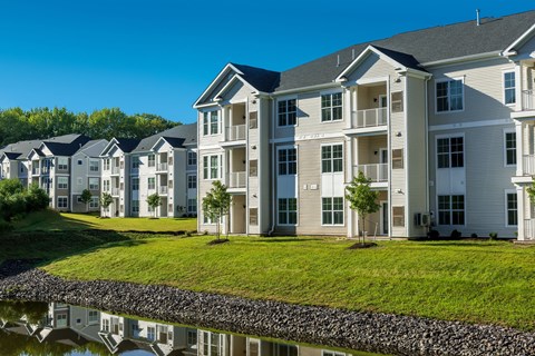 an apartment building with a pond in front of it an apartment building with a pond in front of it at The Residences at Crosstree, Freeport, 04096