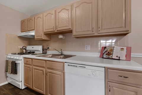 a kitchen with white appliances and wooden cabinets