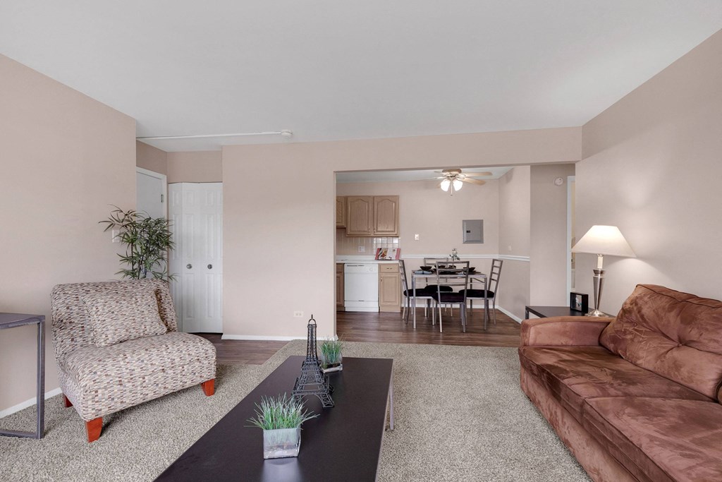 a living room with a leather couch and a coffee table at St Charles Square Apartments, Carol Stream, IL
