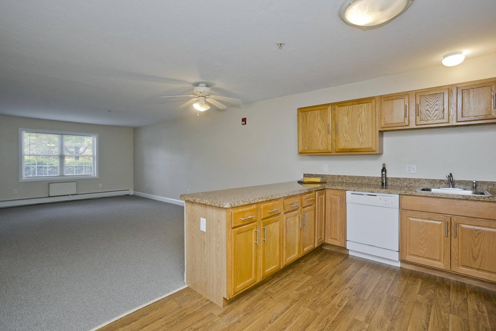 an empty kitchen with wooden cabinets and a counter top