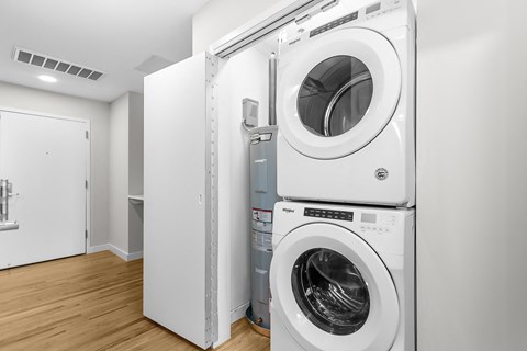 a white washer and dryer in a white laundry room with a door at 1188 Lofts, Connecticut