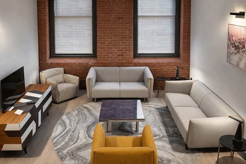 A living room with a yellow chair and a grey sofa.