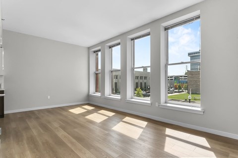 an empty living room with windows and wood floors at 1188 Lofts, Bridgeport