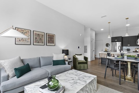 A modern living room with a grey sofa and a marble coffee table.