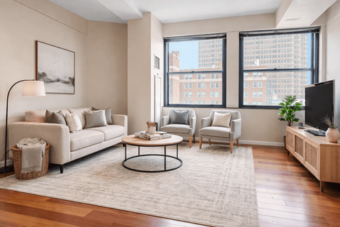 A living room with a white sofa, a coffee table, and a television.