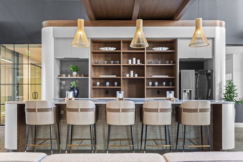 a kitchen with bar stools in front of a counter with chairs