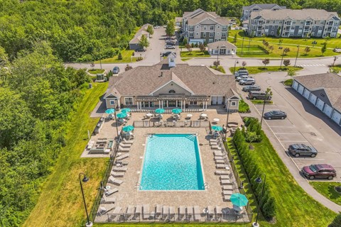 Aerial view of the pool a aerial view of a swimming pool and a house with umbrellas at The Beacon at Gateway Apartments, Scarborough, ME, 04074