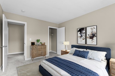 A bedroom with a large bed and a wooden dresser.