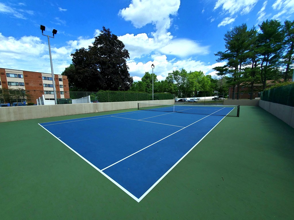 a blue and green tennis court on a sunny day at Greenfield Village Apartments, Rocky Hill, CT