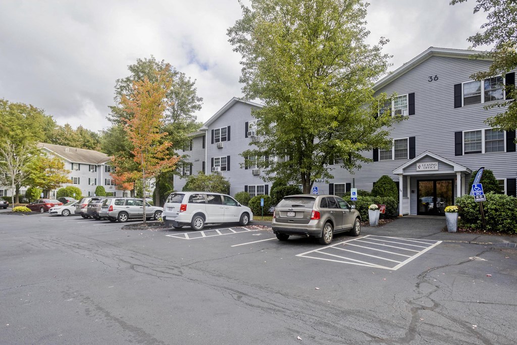 a parking lot with cars in front of an apartment building