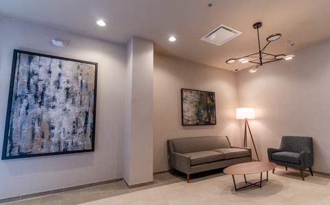 a living room with a couch and a painting on the wall