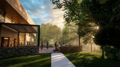 A modern house with a stone wall and people walking around outside.