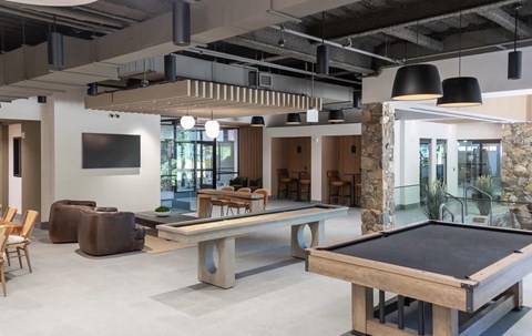A room with a pool table and a tv.