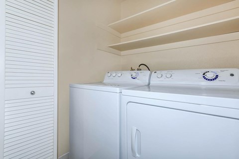 A white washing machine and dryer in a laundry room.