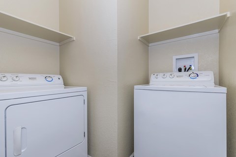 A white washing machine and dryer in a small laundry room.