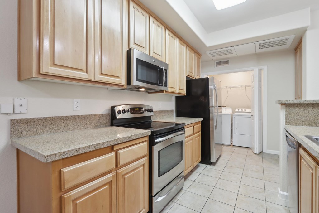 A kitchen with black appliances and wooden cabinets.