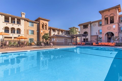 A swimming pool in front of a row of houses.