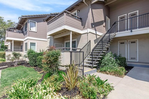 A modern two-story house with a balcony and a staircase.