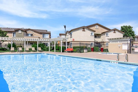 A large swimming pool in front of apartment buildings.