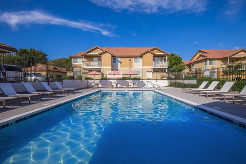 A swimming pool in front of apartment buildings.
