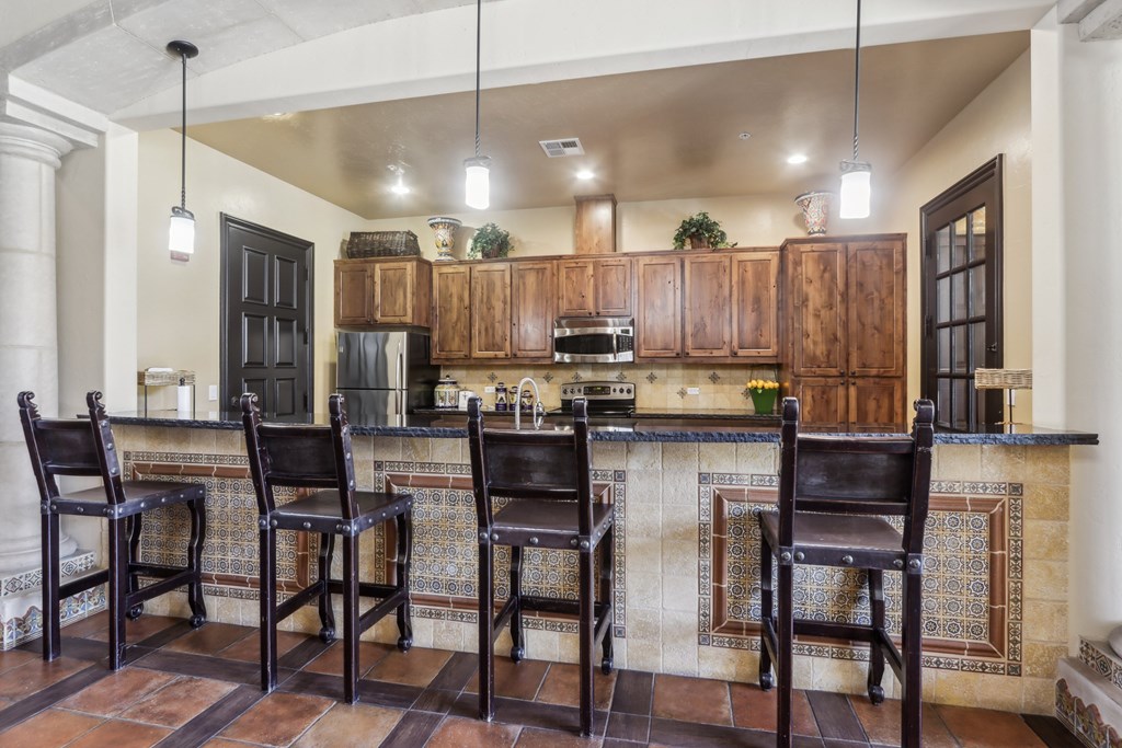 A kitchen with a bar area and four chairs.