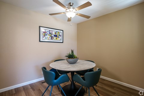 A dining room with a round table and four chairs.