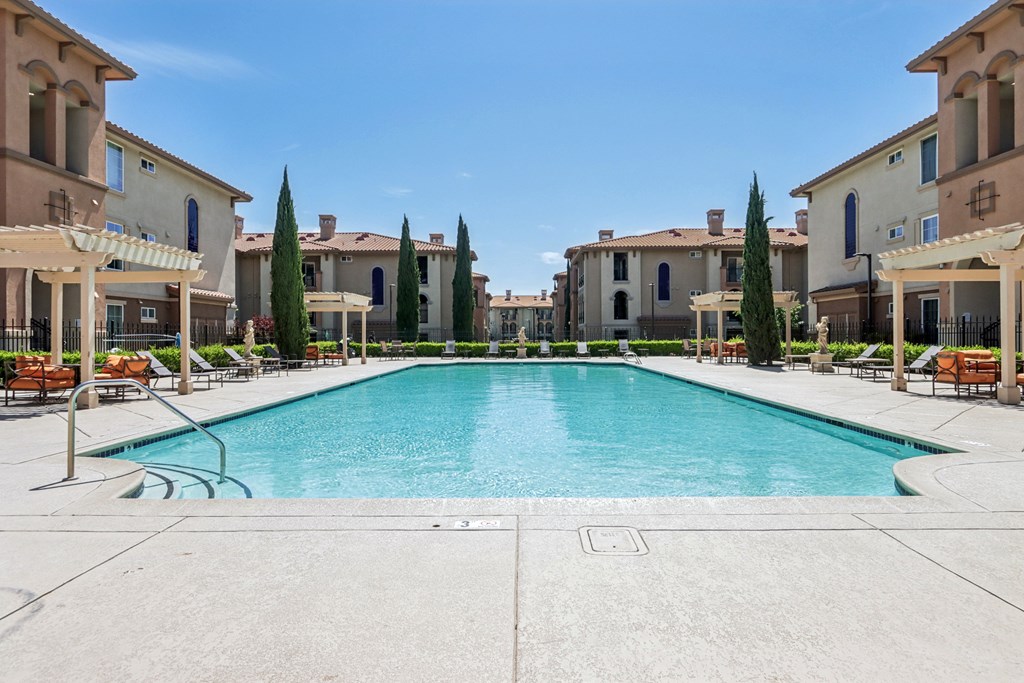 A large swimming pool in the middle of a resort area.