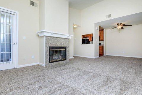 A living room with a fireplace and a ceiling fan.