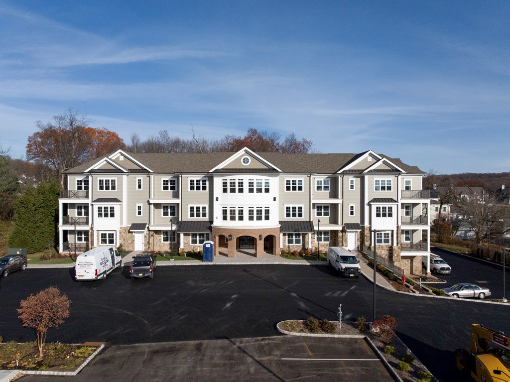 A large white building with a parking lot in front.