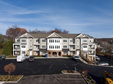 A large white building with a parking lot in front.