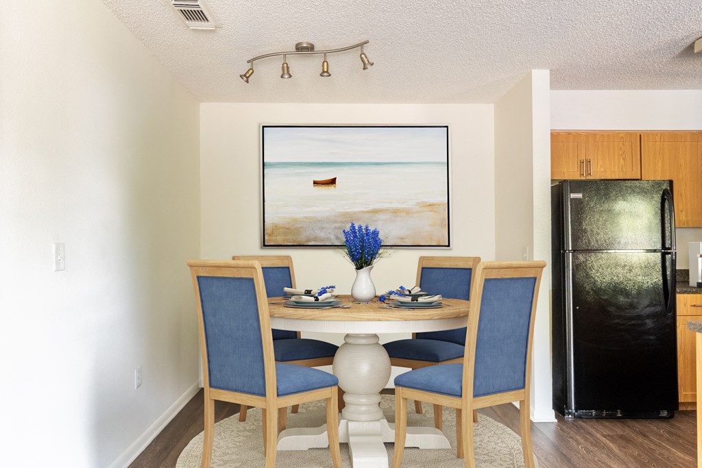View of Timber Chase Model Dining Nook - staged with table and chairs with track lighting.