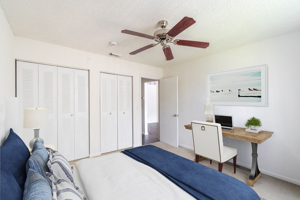 View of Timber Chase Model Bedroom, staged with bed, desk, chair, and ceiling fan