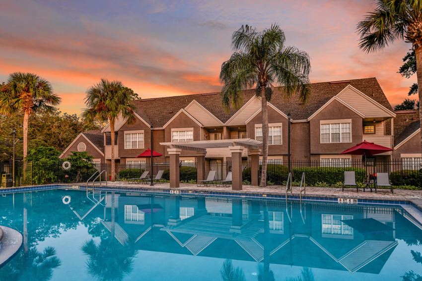 Bloomingdale Woods Apartments Valrico Florida Building Exteriors with Pool in Foreground, and Mature Palm Trees, with Sunset in background - Photo Gallery