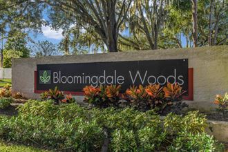 Bloomingdale Woods Apartments Valrico Florida Entrance Sign with Beautiful flowers and shrubs framing the sign