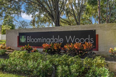Bloomingdale Woods Apartments Valrico Florida Entrance Sign with Beautiful flowers and shrubs framing the sign