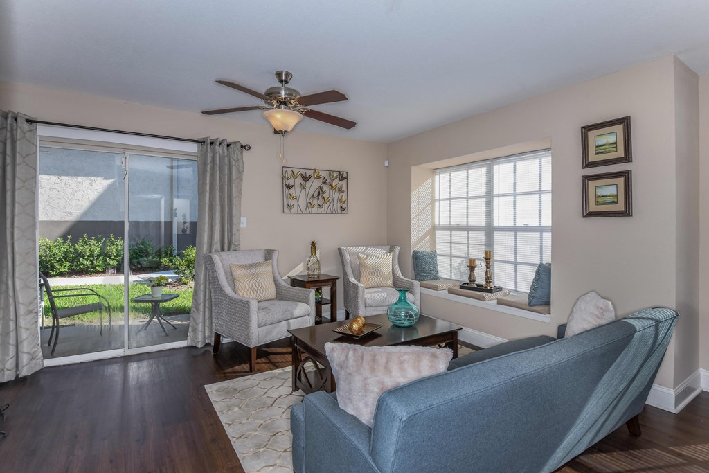 Bloomingdale Woods Apartments Valrico Florida Model Apartment Living Room with Couch and Lounge Chairs with View of Walkout Patio and Ceiling Fan