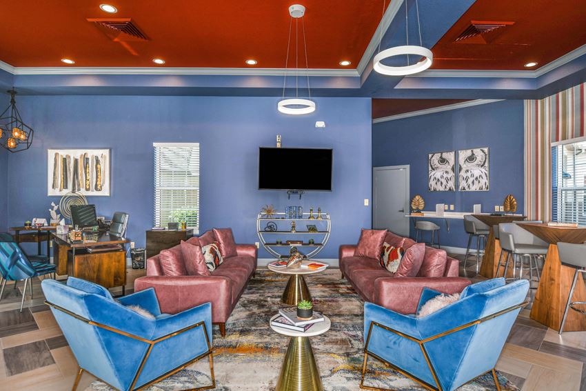Bloomingdale Woods Apartments Valrico Florida Clubhouse Interior with 2 Couches, 2 Lounge Chairs, High-Top Tables with Chairs and Decorative Coffee Tables and Lighting with TV - Photo Gallery
