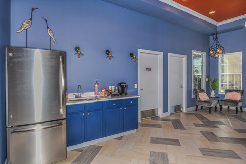 a kitchen with blue cabinets and a stainless steel refrigerator