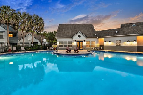 A swimming pool in front of the Leasing Clubhouse rear exit with modern pool furniture.