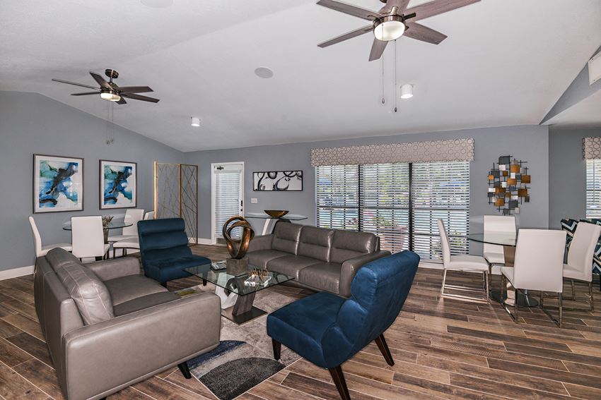 View of Brookside Manor renovated and redecorated clubhouse lounge with comfortable couches and lounge chairs, tastefully decorated with inspired art pieces, with wood plank flooring