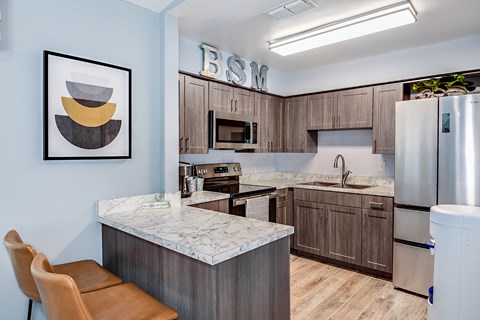 a kitchen with a marble counter top and wooden cabinets