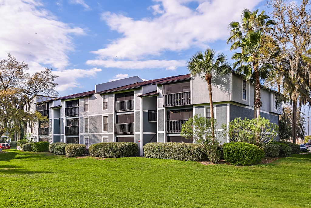 View of Brookside Manor Apartment Building and bright green lush grass and mature trees